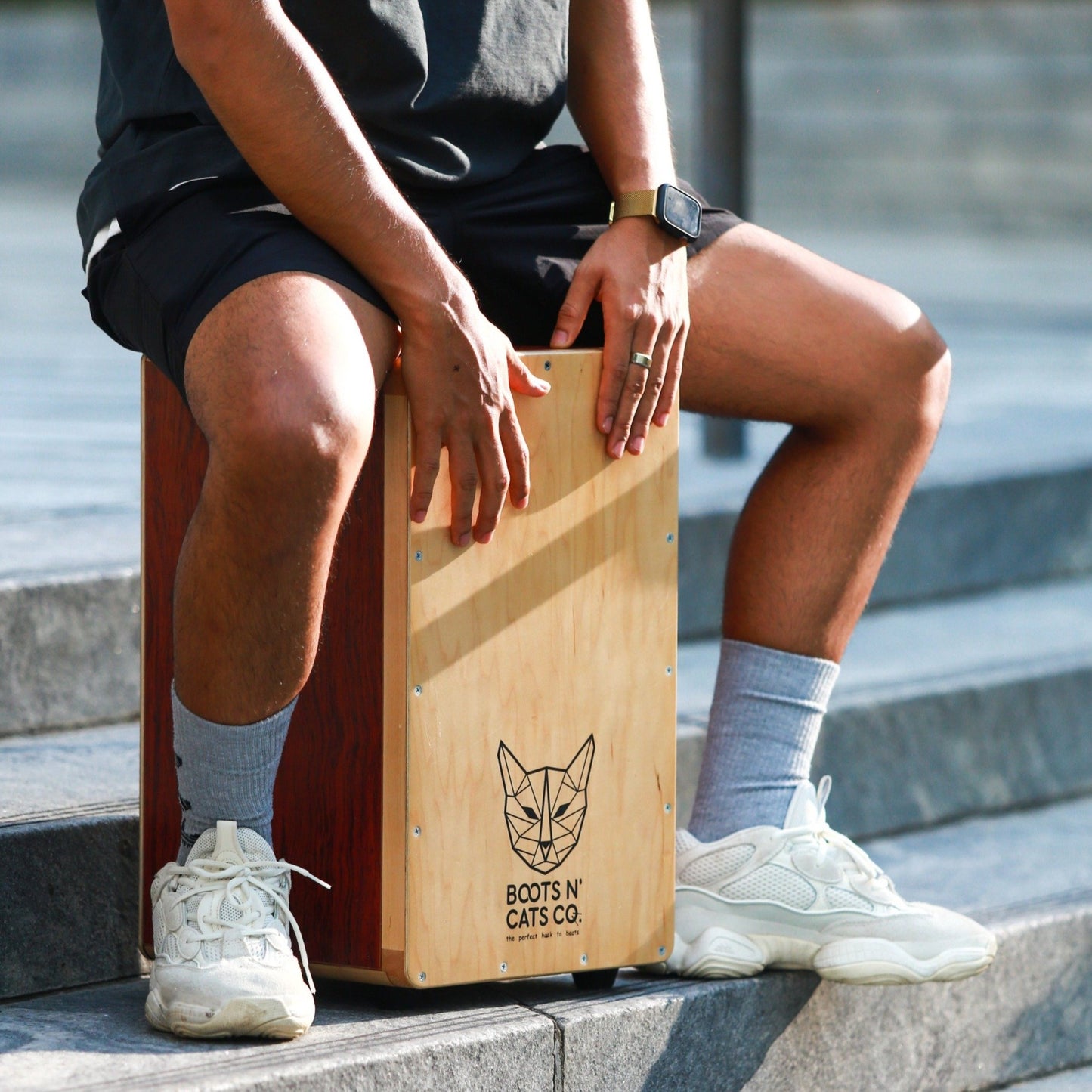 A guy playing Boots N Cats collapsible cajon.